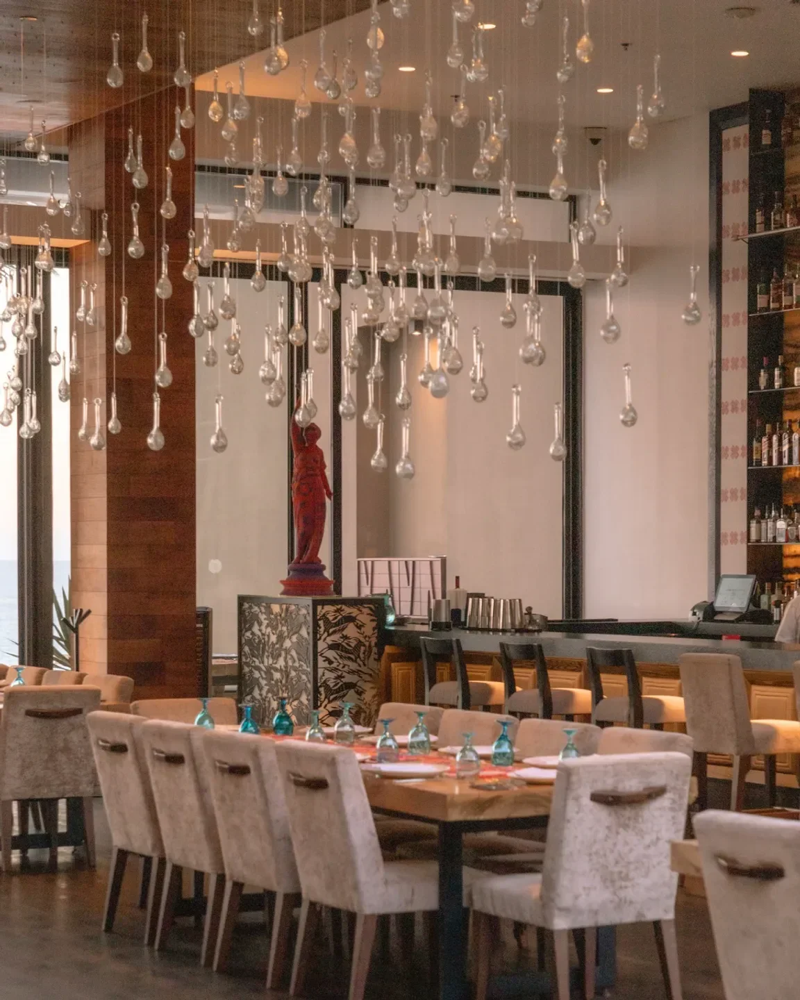 Elegant dining room at Café des Artistes in San José del Cabo with unique glass light fixtures.