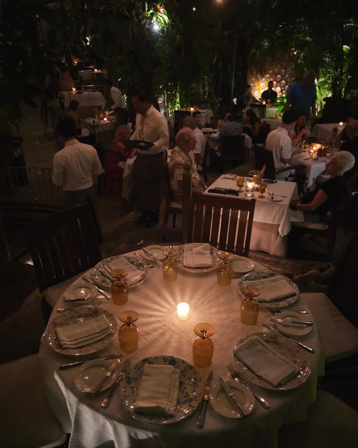 Elegant dining at Café des Artistes in Puerto Vallarta. Romantic restaurant interior with candlelit tables and tropical surroundings.