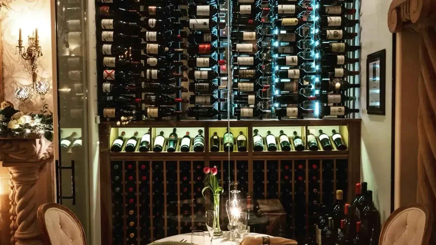 Wine cellar inside Café Monarch in Scottsdale, with bottles and a dining table.