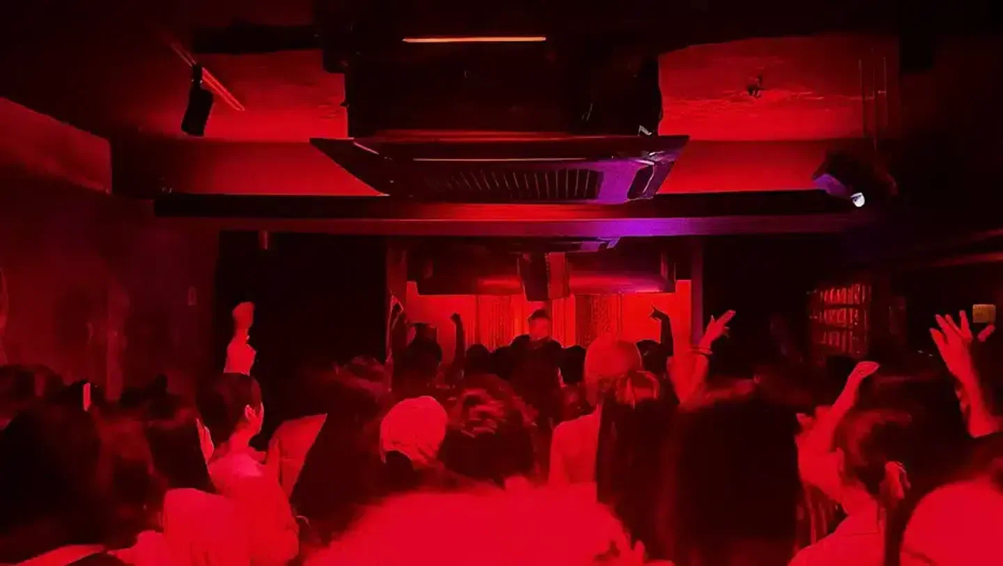 Energetic dance floor at Cakeshop nightclub in Seoul, with red ambient lighting and crowd.