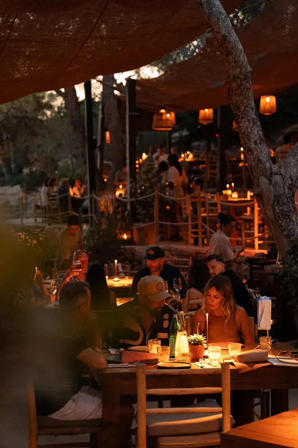 Cozy evening ambiance at Cala Gracioneta restaurant in Ibiza with candlelit tables and rustic decor.