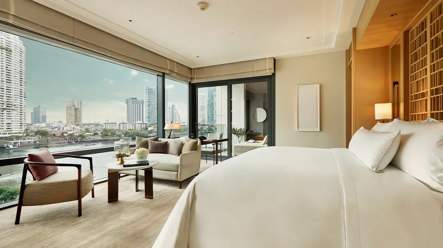 Luxury river view bedroom at Capella Bangkok hotel, overlooking the Bangkok skyline.
