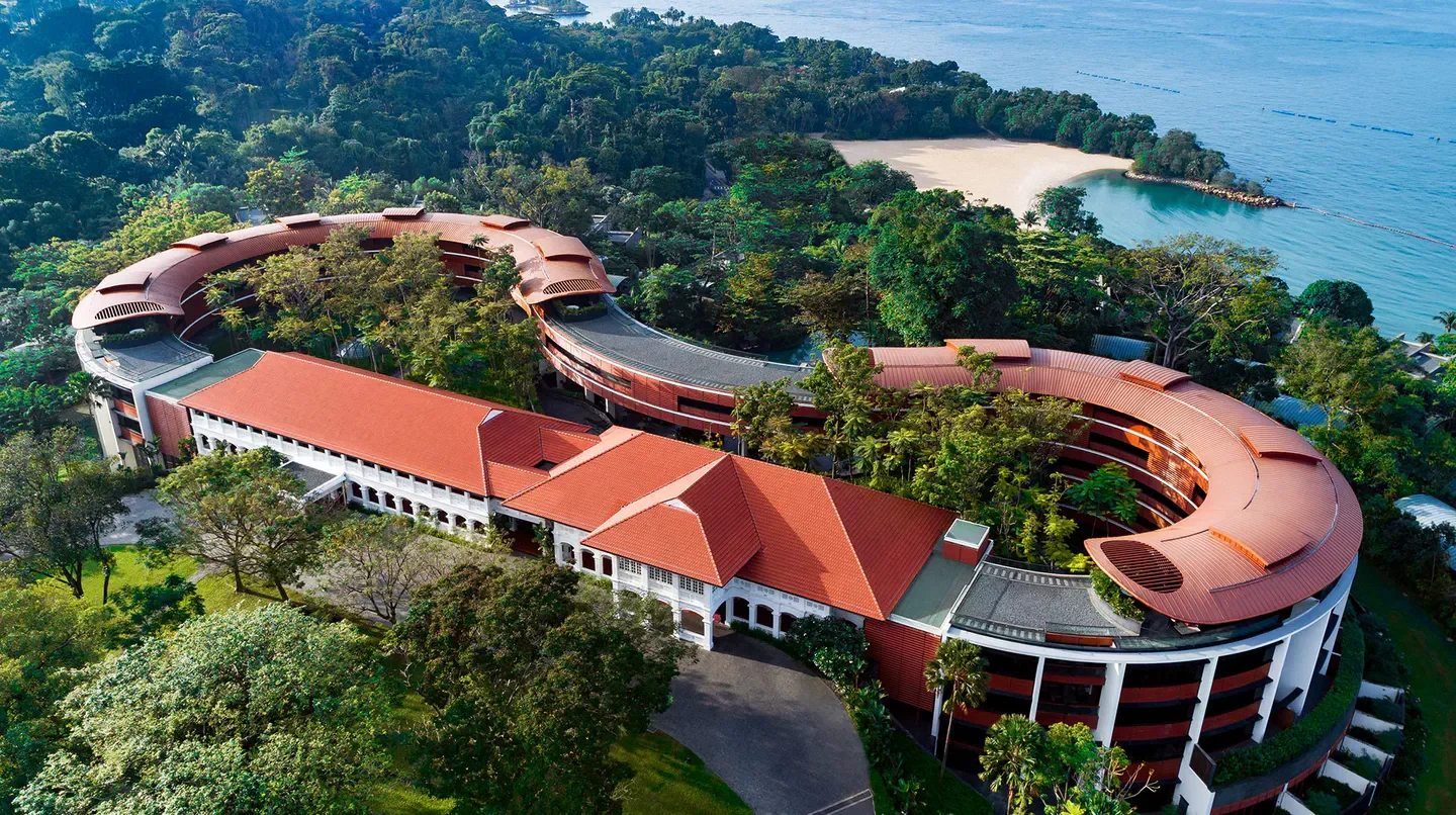 Aerial view of Capella Singapore hotel, surrounded by lush greenery in Singapore.