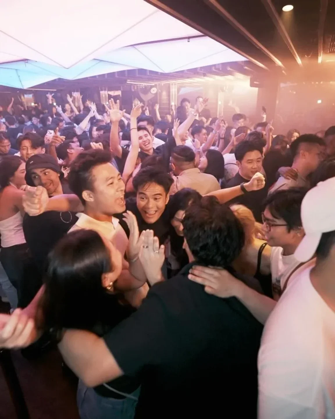 Energetic crowd partying at Capital nightclub in Singapore, enjoying the nightlife with friends.