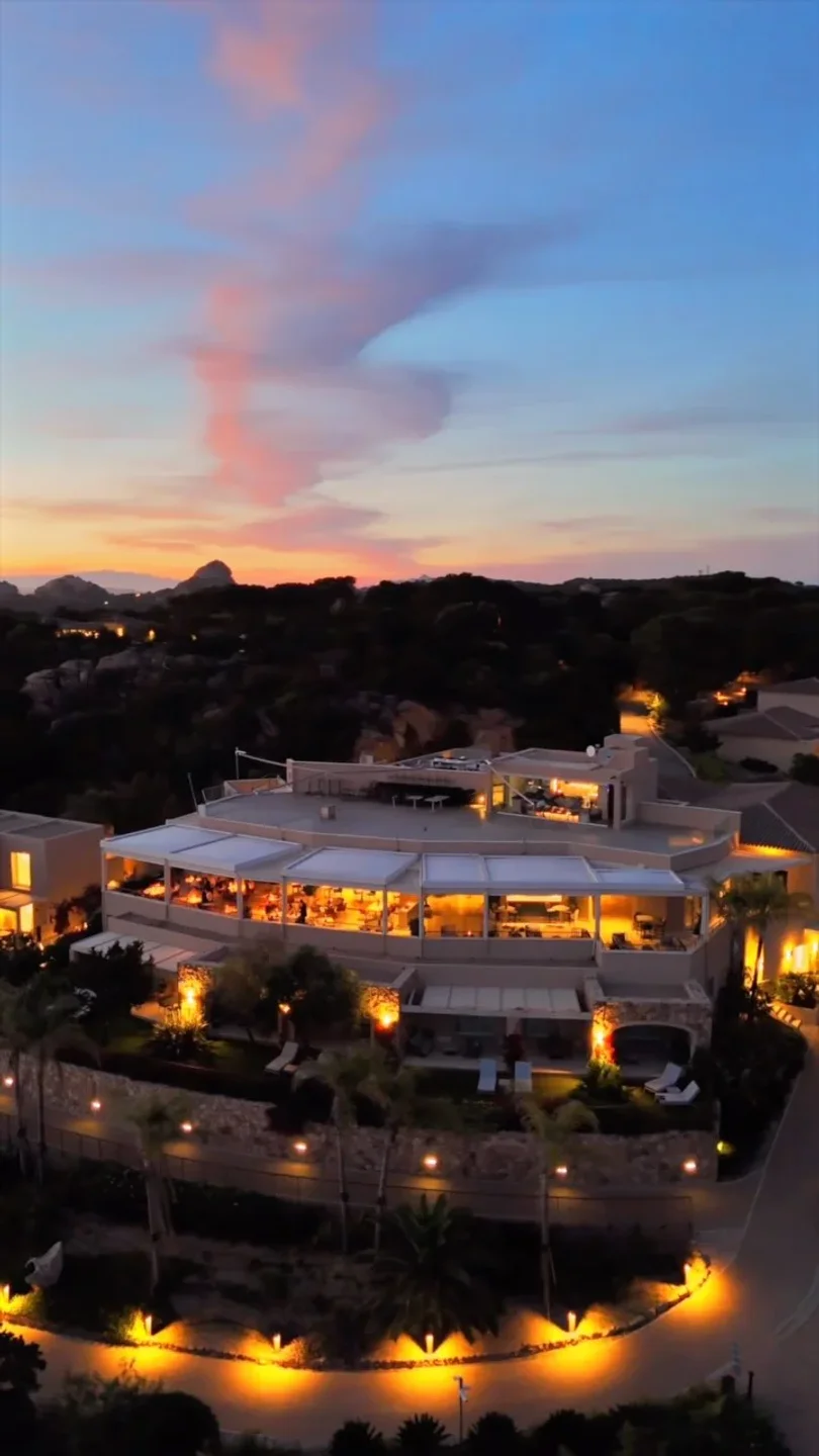 Capogiro restaurant exterior in Porto Cervo with illuminated dining and scenic sunset sky