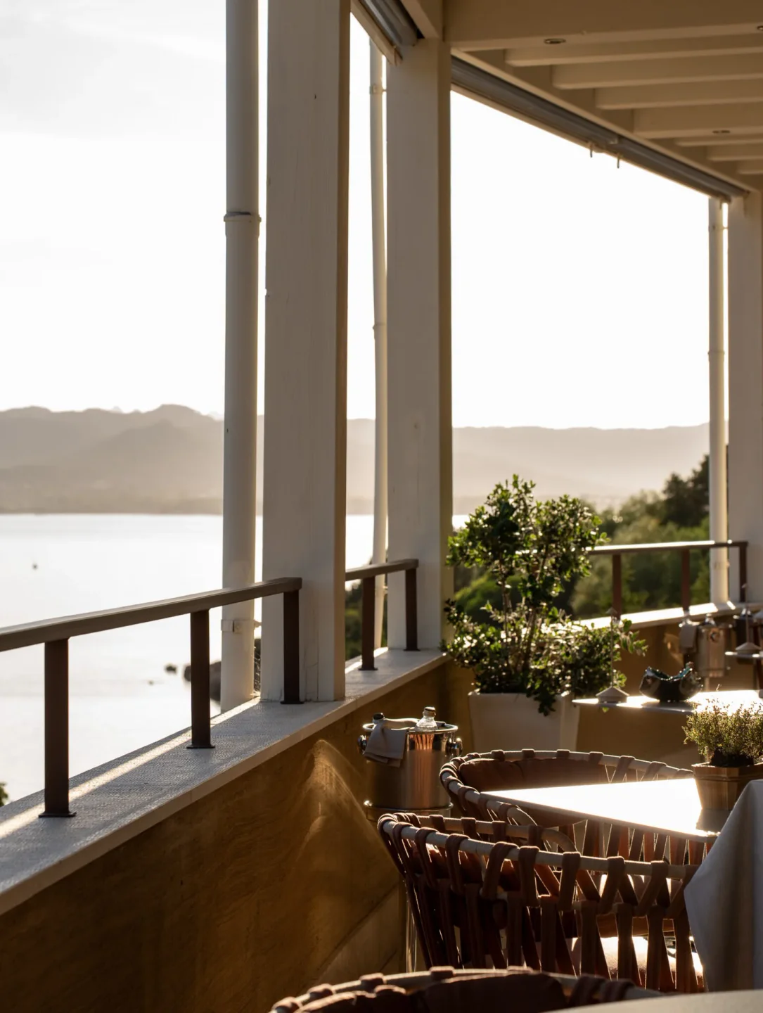 Capogiro Restaurant in Sardinia offers outdoor seating with a beautiful sea view at sunset.