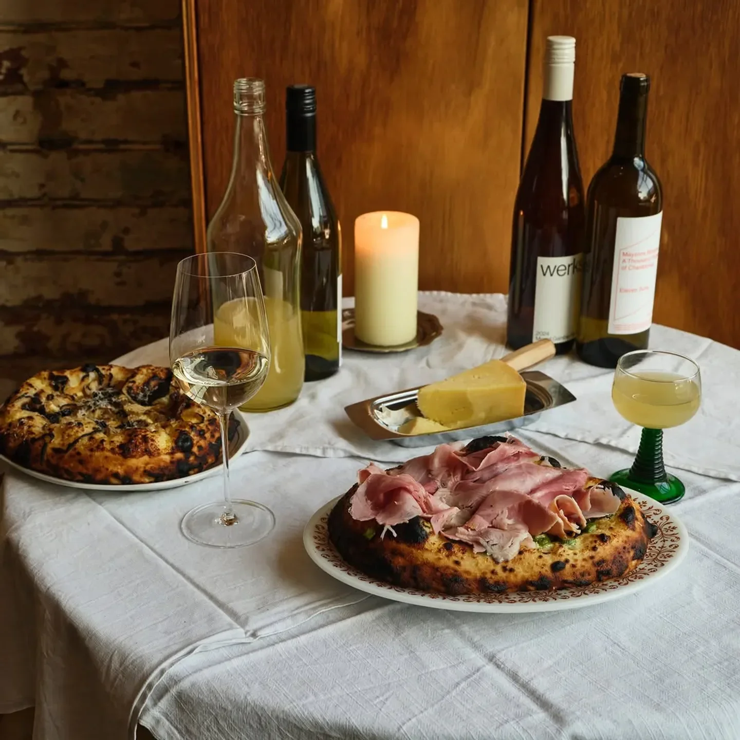 Table setting at Cardwell Cellars in Melbourne, featuring pizzas, wine, and cheese.
