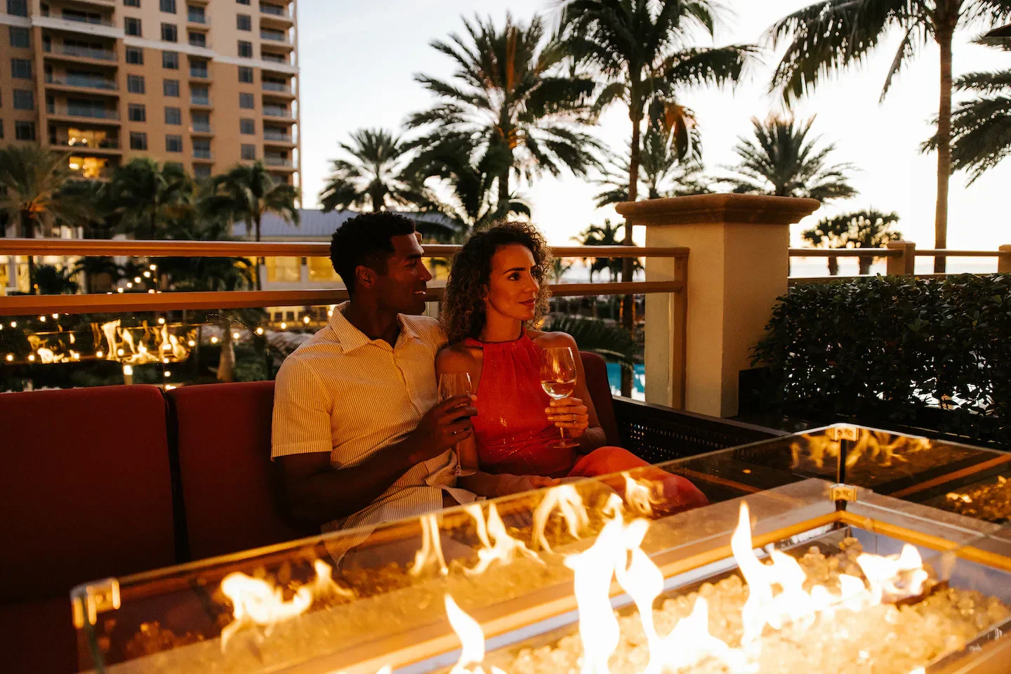 Couple enjoying drinks at Caretta on the Gulf in Clearwater, by the outdoor fire pit.