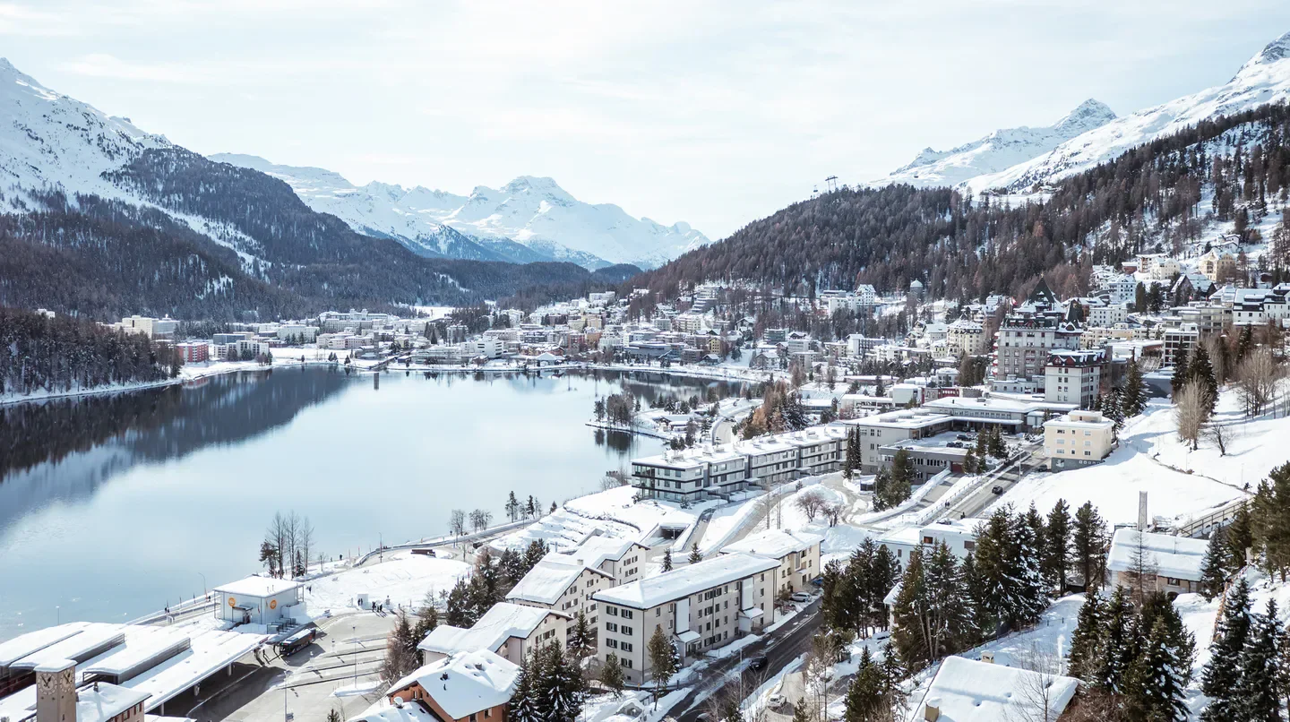 Winter view of Carlton Hotel St. Moritz in St. Moritz, snow-covered buildings and mountains.