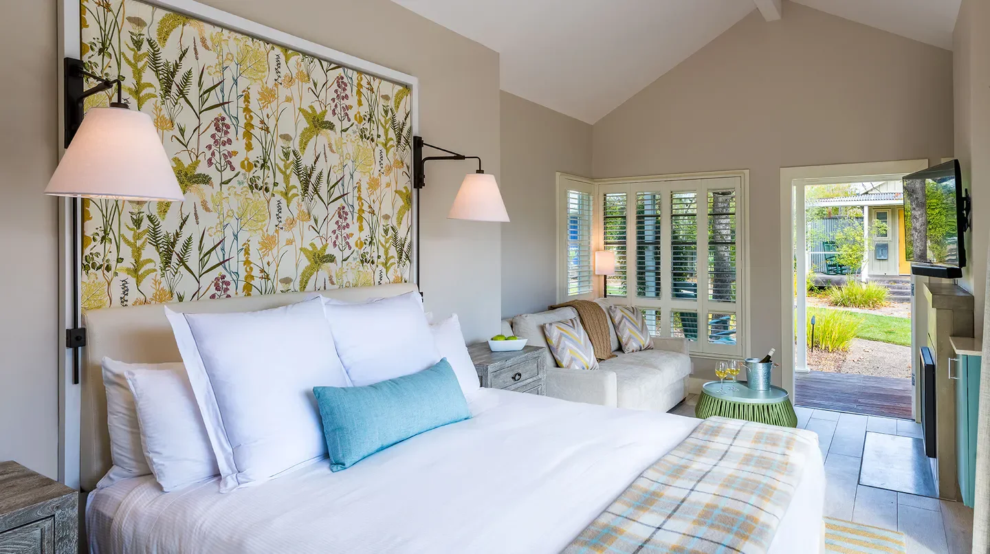 Cozy bedroom at Carneros Resort and Spa in Napa featuring floral decor and outdoor access