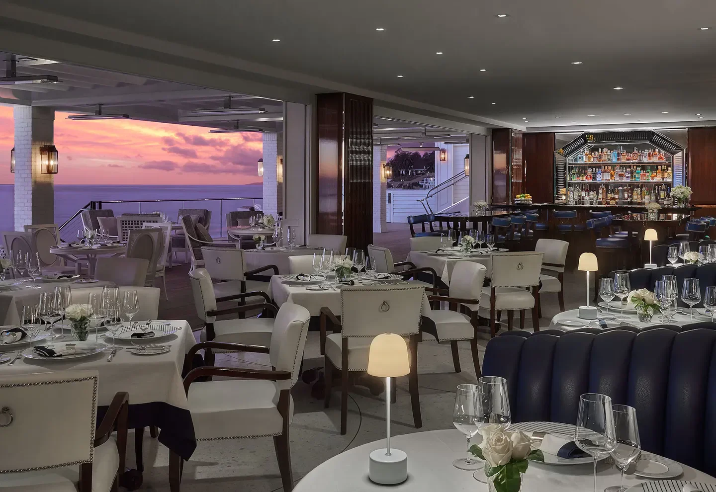 Elegant Caruso's restaurant interior in the Santa Ynez Valley with sunset views and a bar.