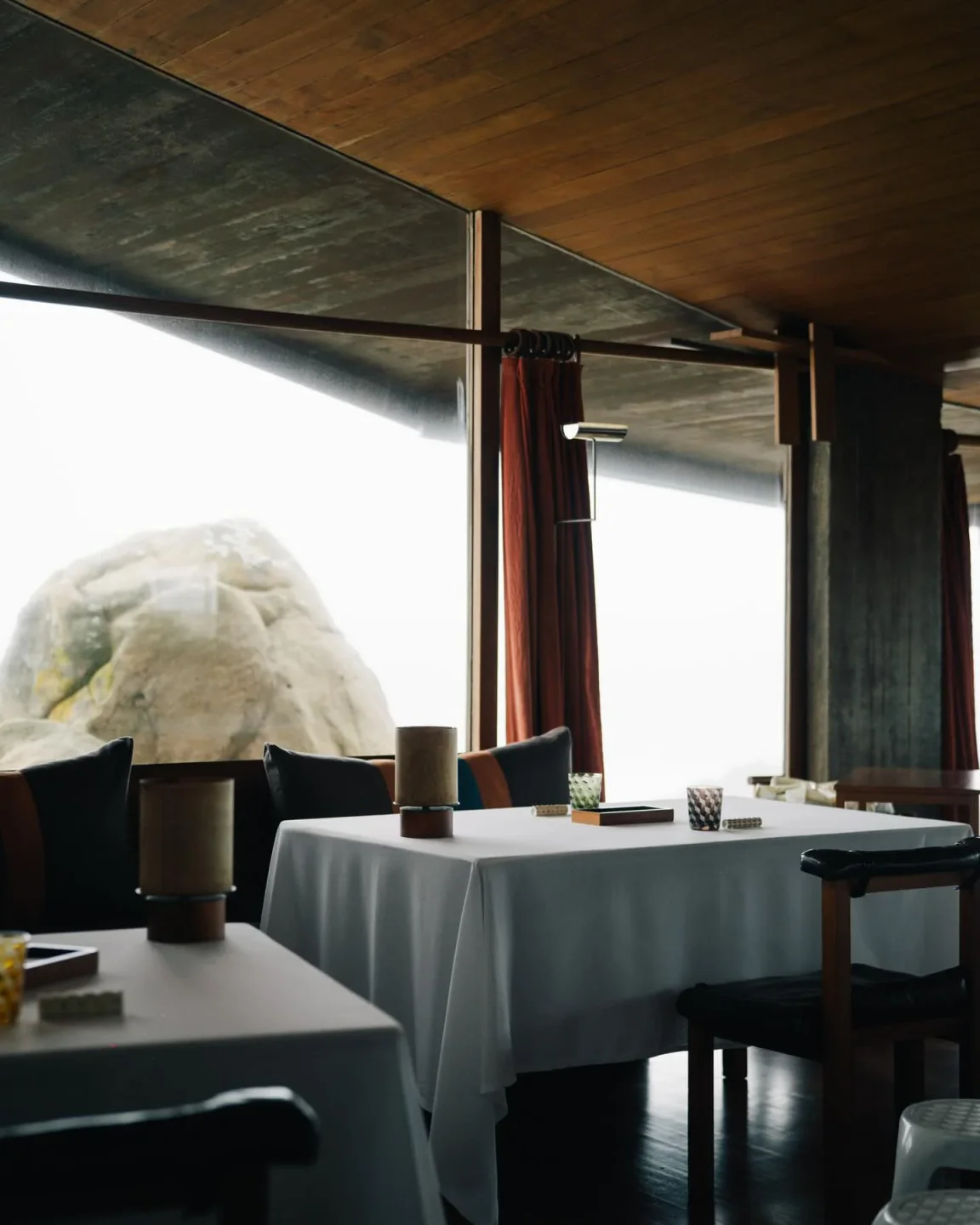 Interior dining space at Casa de Chá da Boa Nova in Porto, featuring tables with white tablecloths and ocean view