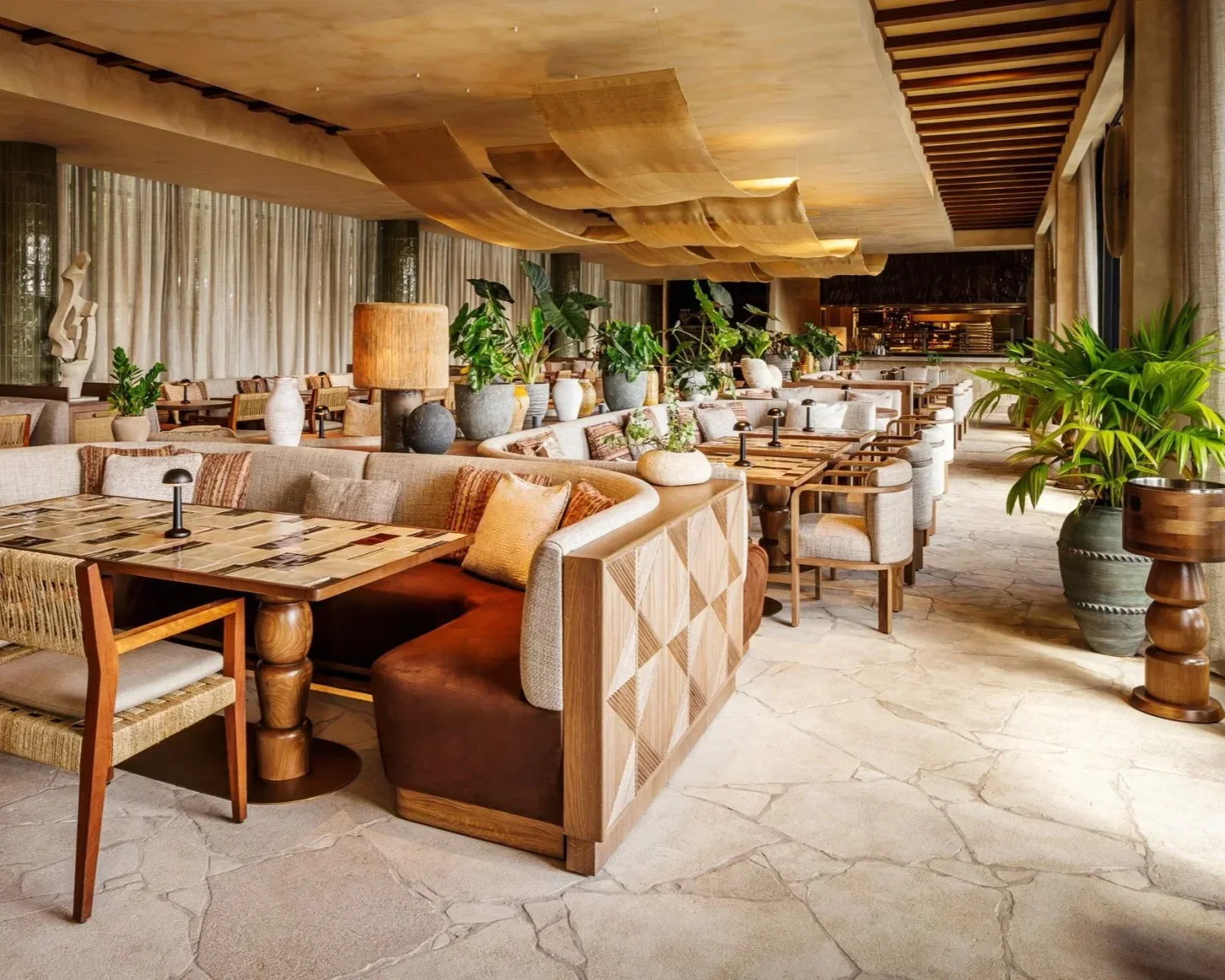 Casa Neos Miami restaurant interior featuring modern seating, natural light, and lush greenery