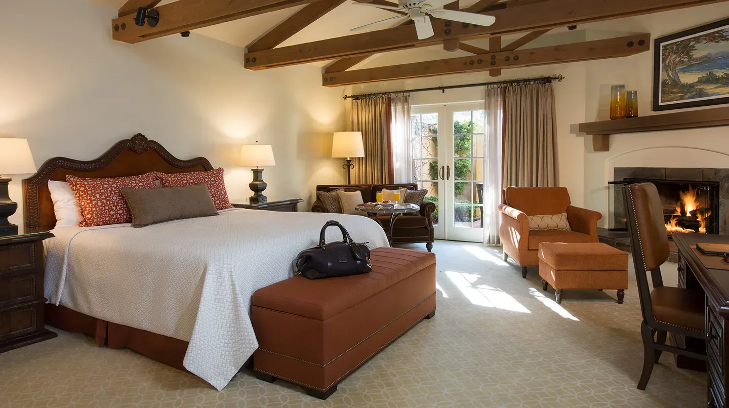 Cozy bedroom at Casa Palmero at Pebble Beach, Monterey, with fireplace and comfortable furnishings.