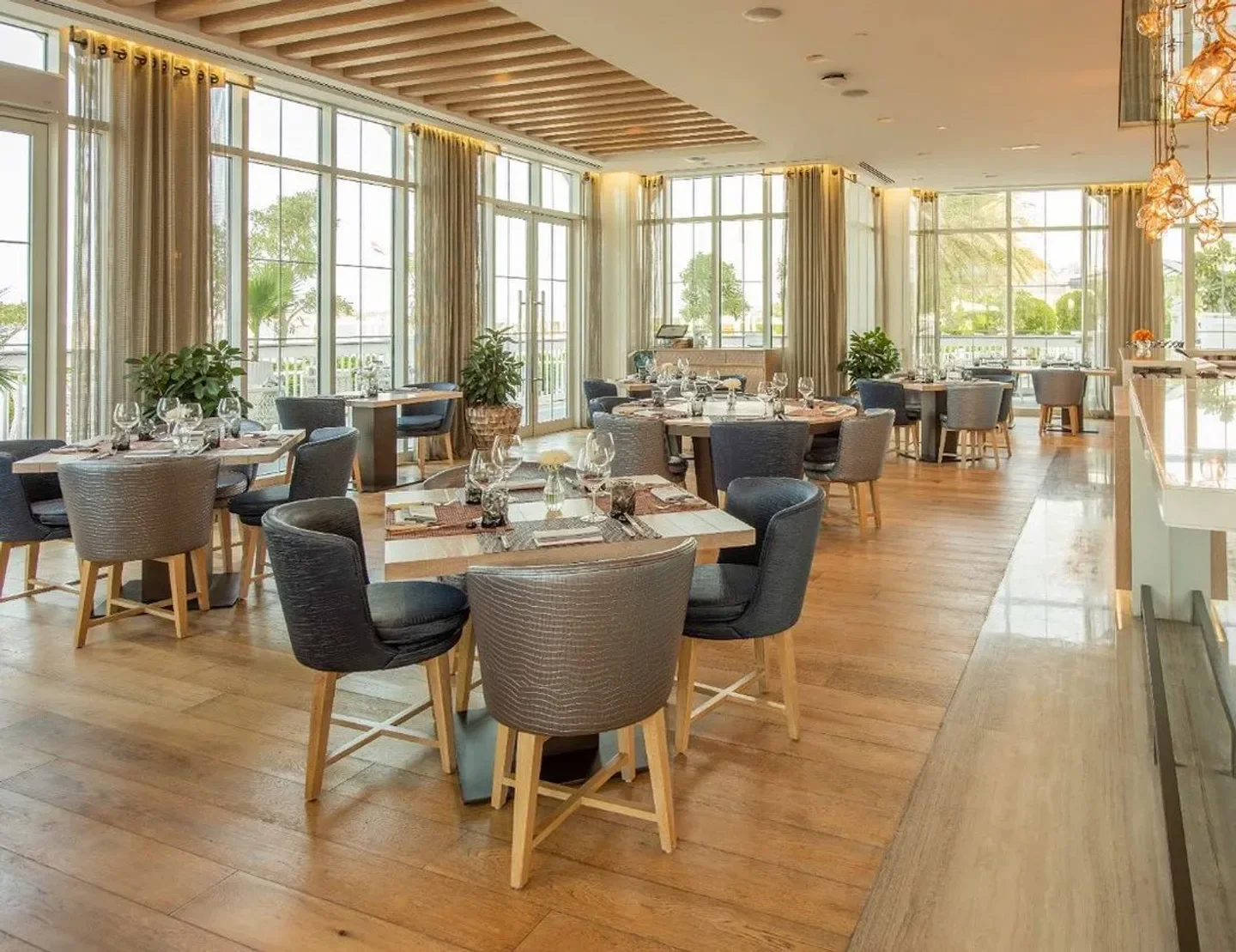 Interior of Catch restaurant in Abu Dhabi, with elegant seating and large windows.