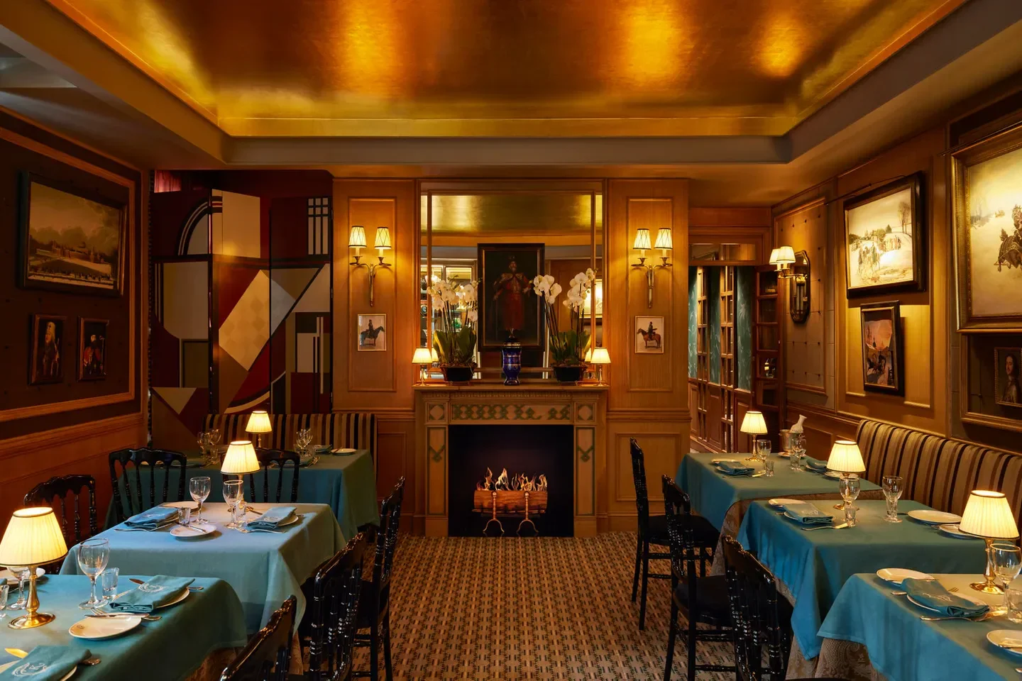 Elegant dining room at Caviar Kaspia in Paris, featuring a fireplace and art.