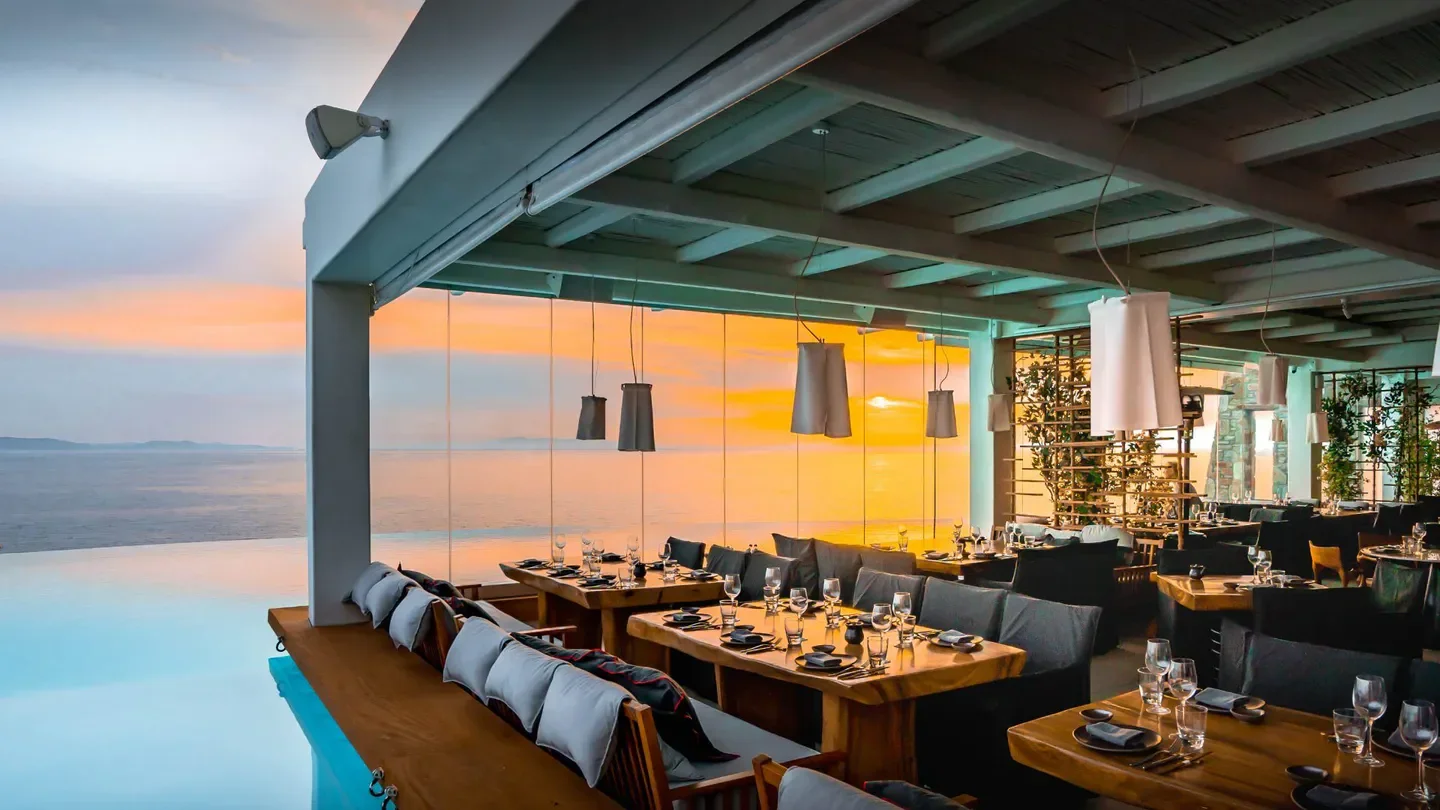 Restaurant view at sunset at Cavo Tagoo Mykonos, Greece with sea views.