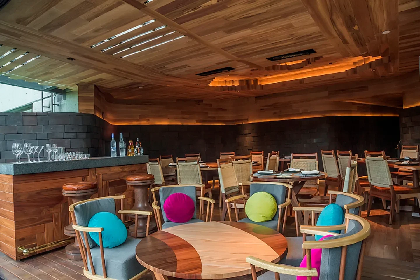 Chapulín in Mexico City: Stylish wooden interior with colorful cushions and inviting ambiance.