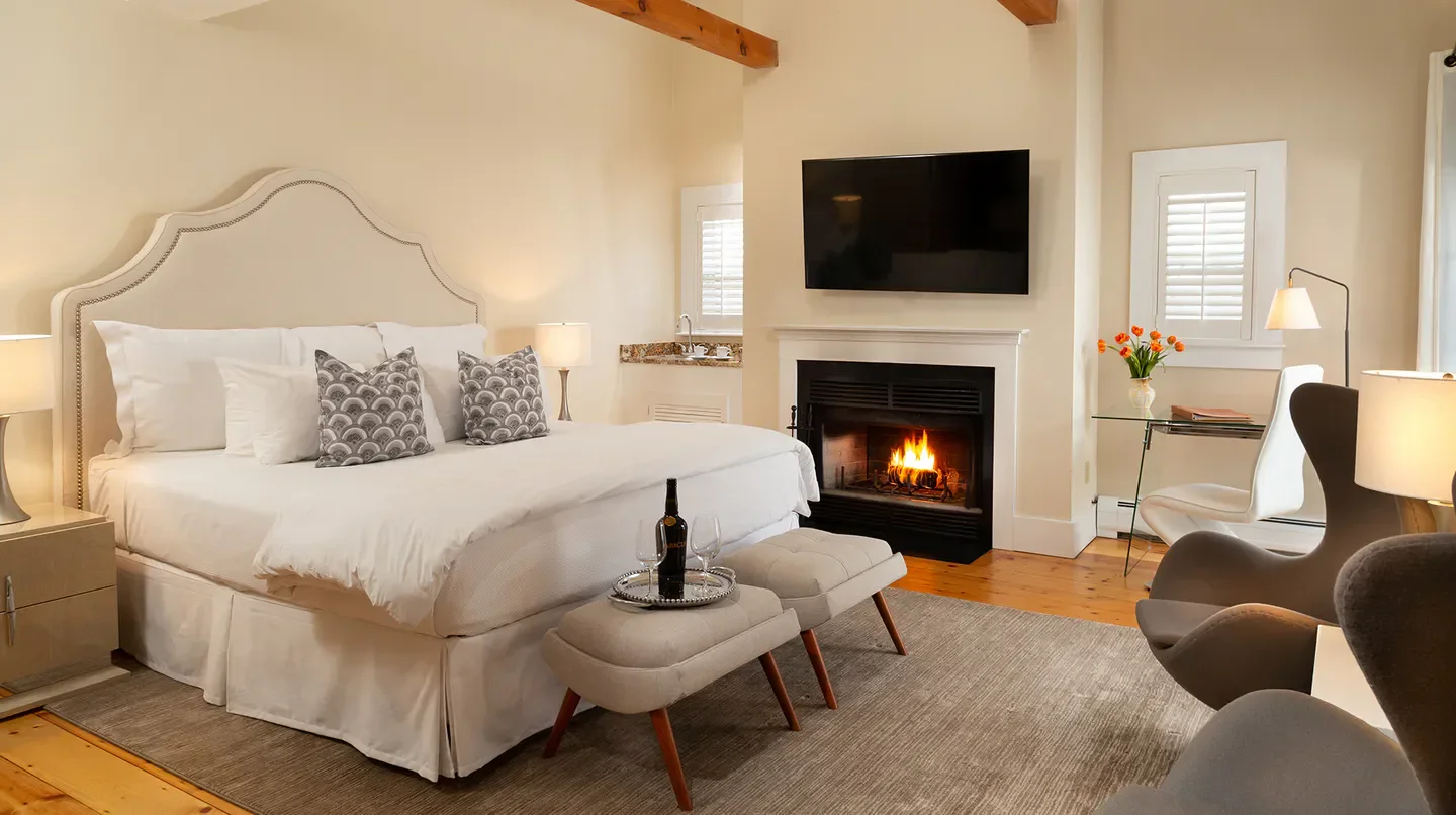 Cozy bedroom with fireplace at Chatham Inn in Nantucket, offering luxury and comfort.