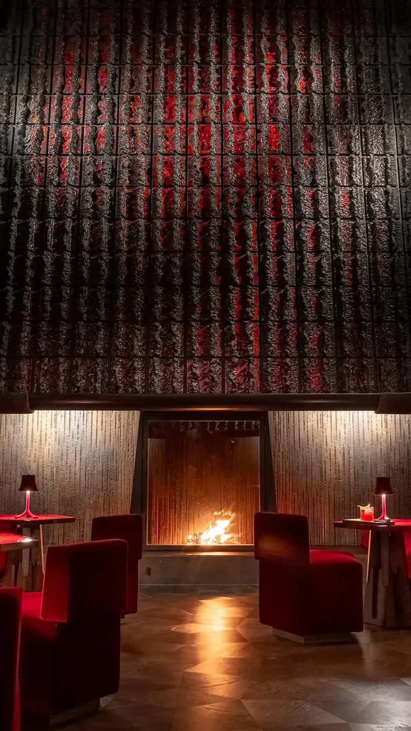 Cozy fireplace at Cheval Blanc by Peter Knogl in Basel, with red chairs and decor