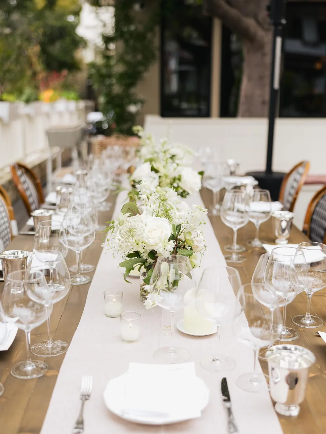 Elegant dining table setting at Chez Noir in Carmel, California, featuring floral arrangements and glassware.