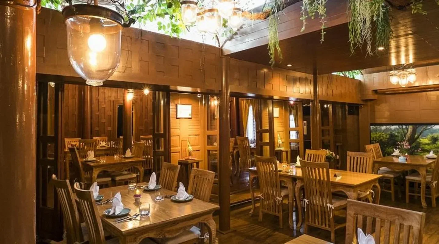 Cozy dining area at Chim by Siam Wisdom, a restaurant in Bangkok, with wooden decor.