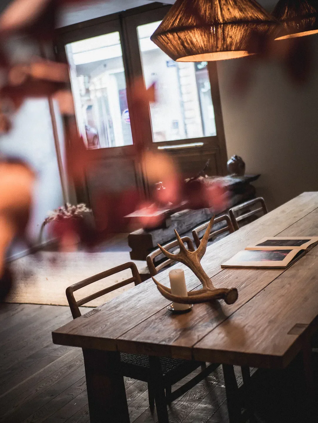 Cozy dining room at CIBO in Bourgogne, featuring rustic wooden table and antler decor.