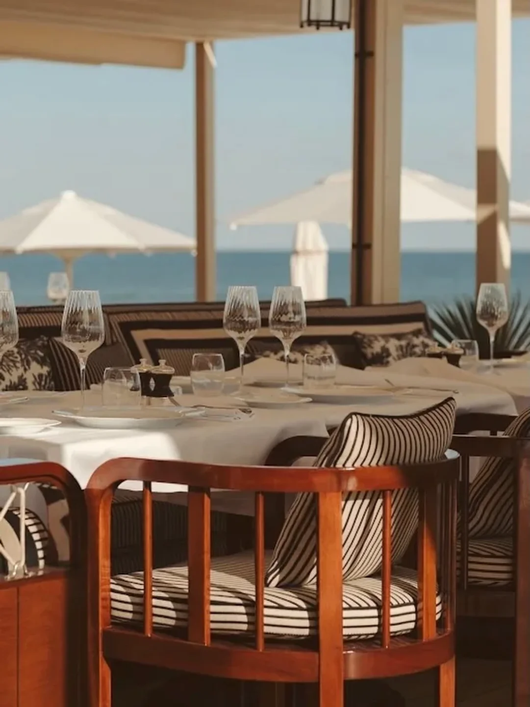 Elegant seaside dining at Ciro's restaurant in Cannes with white tablecloths and ocean views.