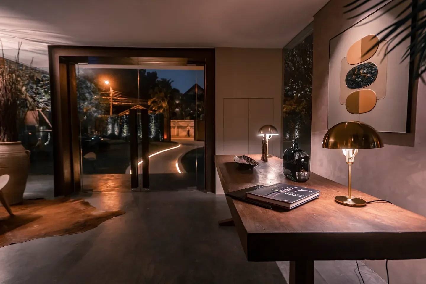 CLARA Bangkok restaurant entrance, showcasing a warmly lit interior and inviting outdoor pathway.