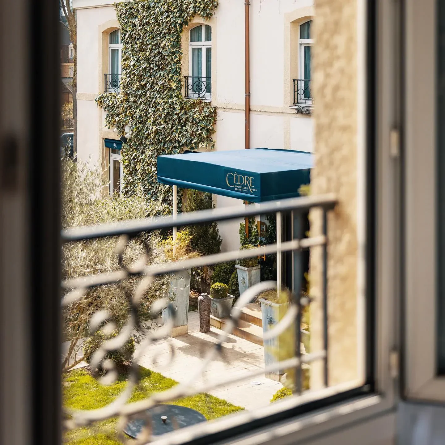 View of the entrance to Clos Du Cédre in Bourgogne, through a decorative window.