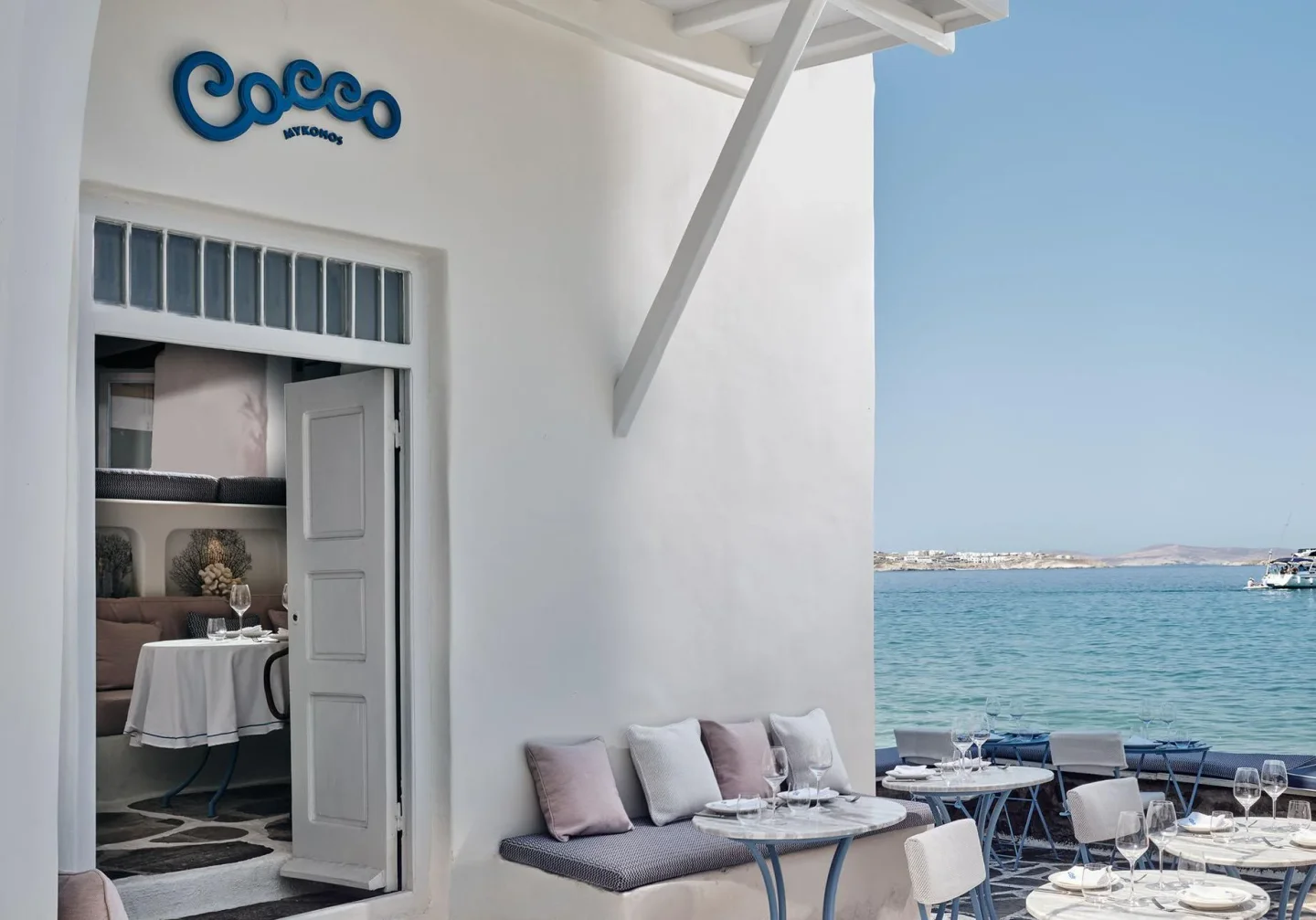 Cocco Mykonos outdoor seating with sea view and elegant tables set for dining