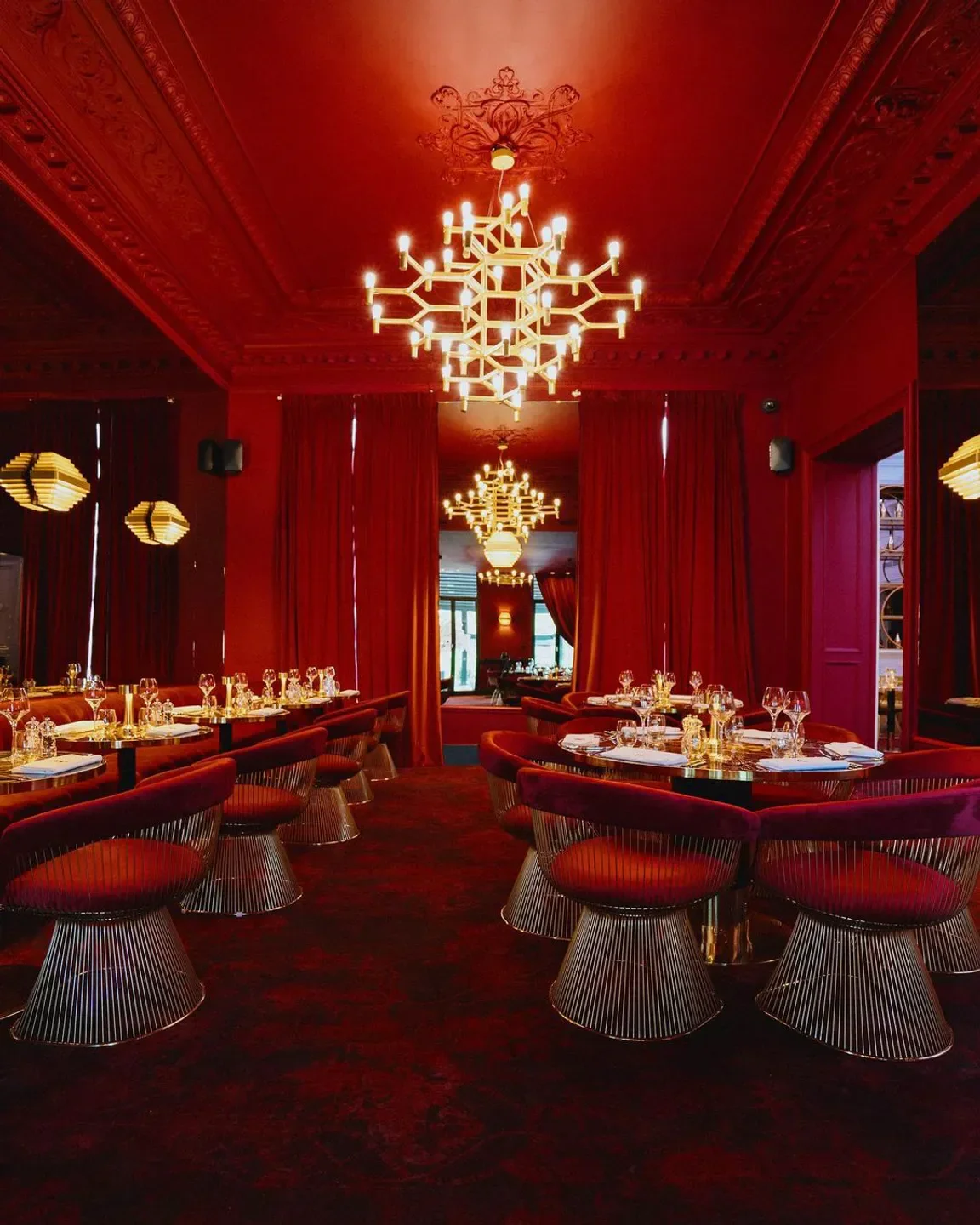Elegant red interior of COCO restaurant in Brussels with stylish seating and lighting.