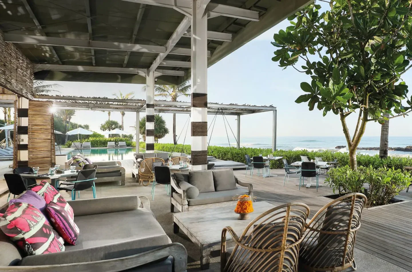 Outdoor dining area at COMO Beach Club in Bali with ocean view and stylish seating.