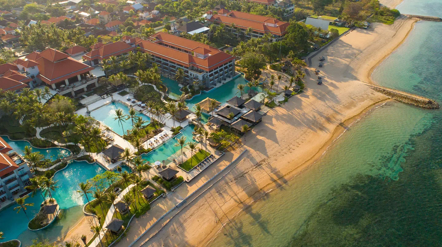 Aerial view of Conrad Bali hotel with pools, beach and ocean in Bali, Indonesia.