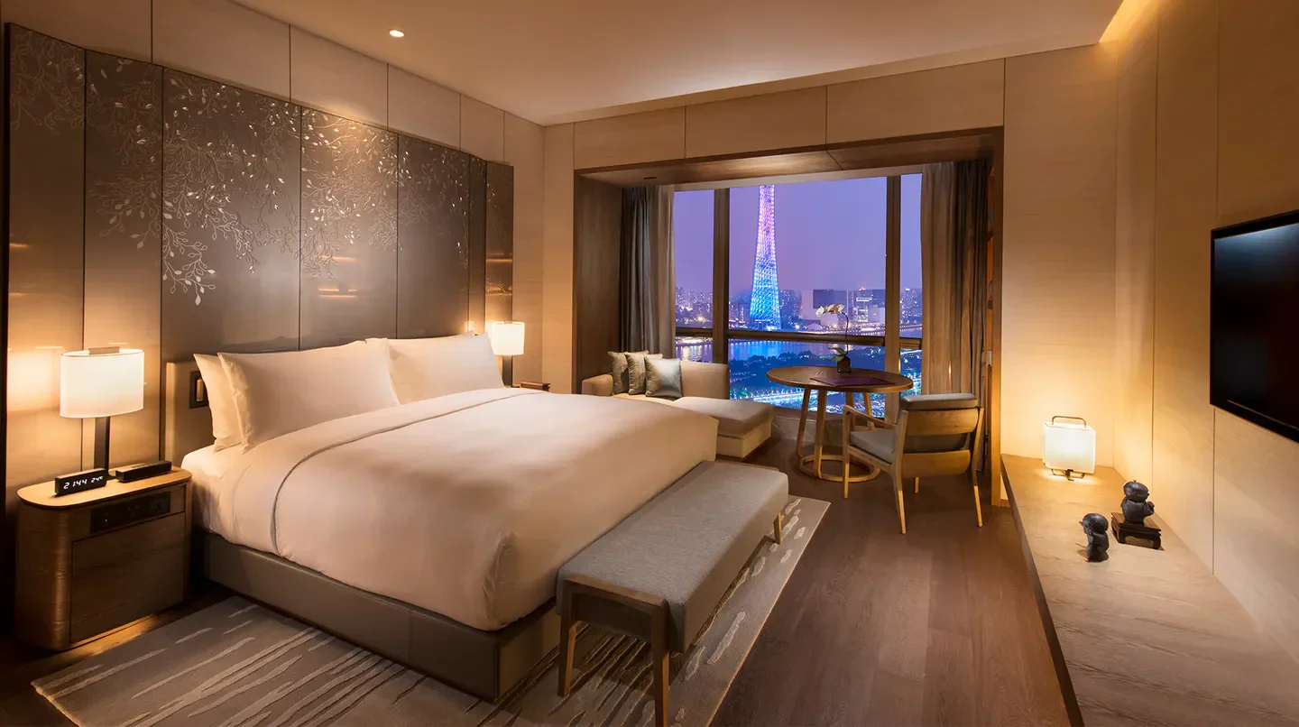Luxury hotel room at Conrad Guangzhou, showcasing city views of Guangzhou at dusk.