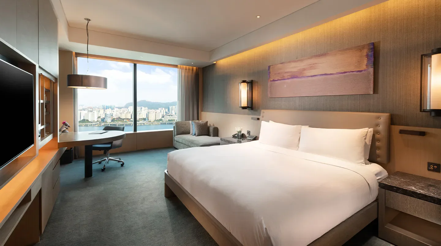 Modern hotel room at Conrad Seoul, featuring a city view of Seoul from the window.