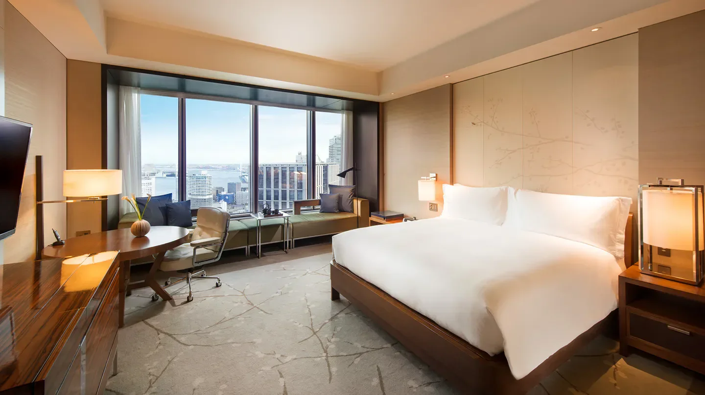 Spacious bedroom at the Conrad Tokyo with stunning city views of Tokyo from the window.