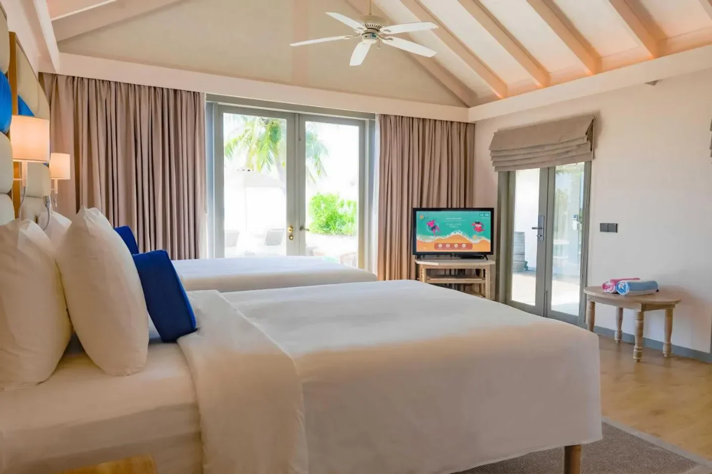 Bright bedroom interior at Cora Cora Maldives hotel with a view of the Maldives scenery.