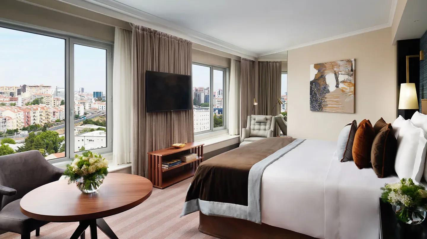 Stylish hotel room at Corinthia Lisbon with views of the city of Lisbon.