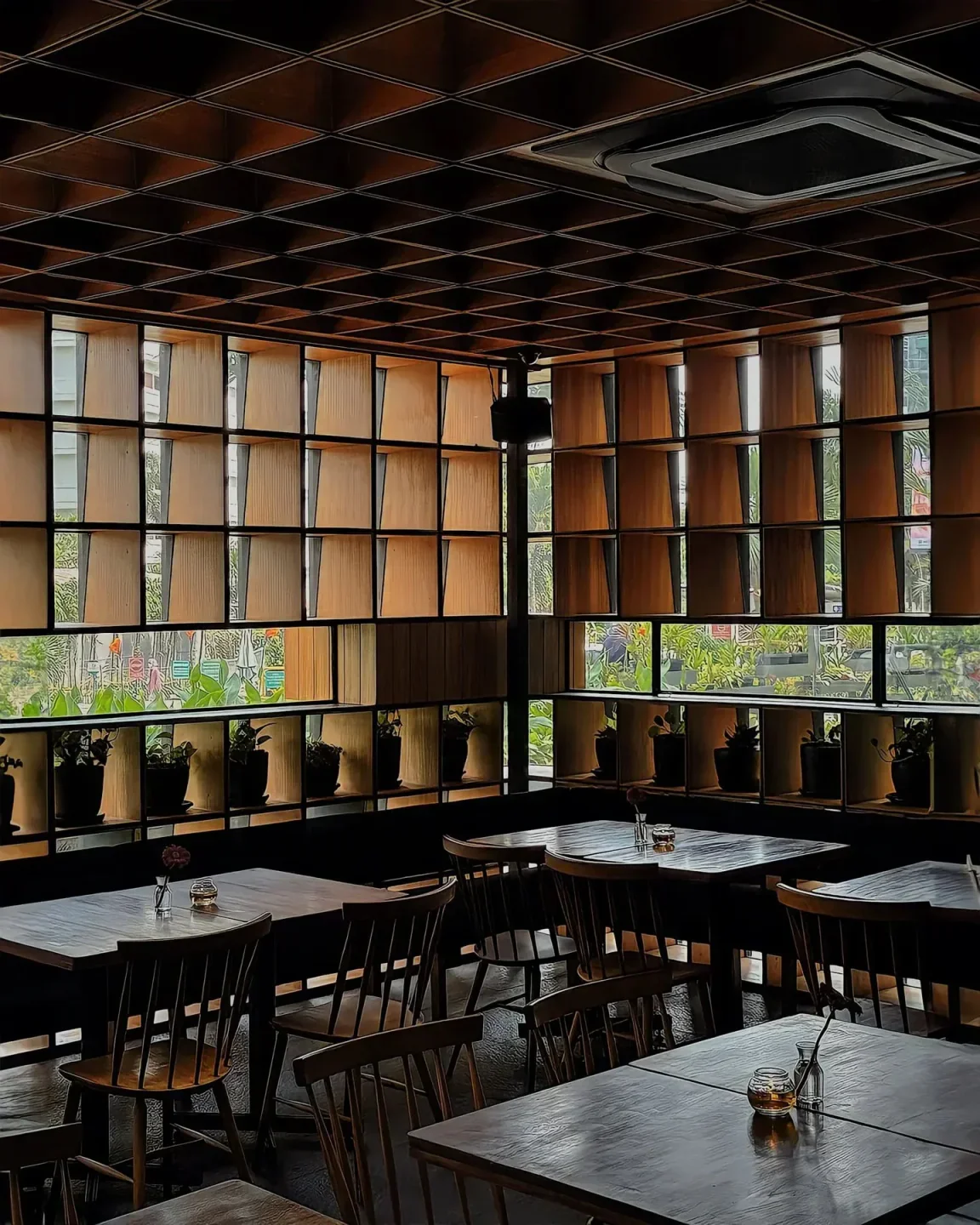 Interior of Cork & Screw restaurant in Jakarta with wooden tables and wall details.