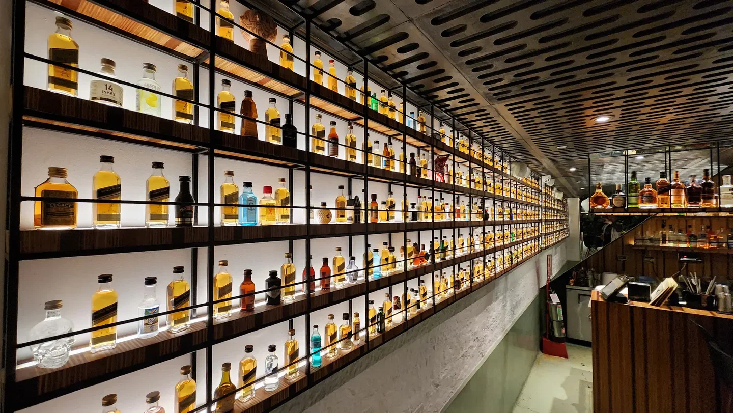 Interior shot of Cosme restaurant in Lima, showcasing a wall of liquor bottles.