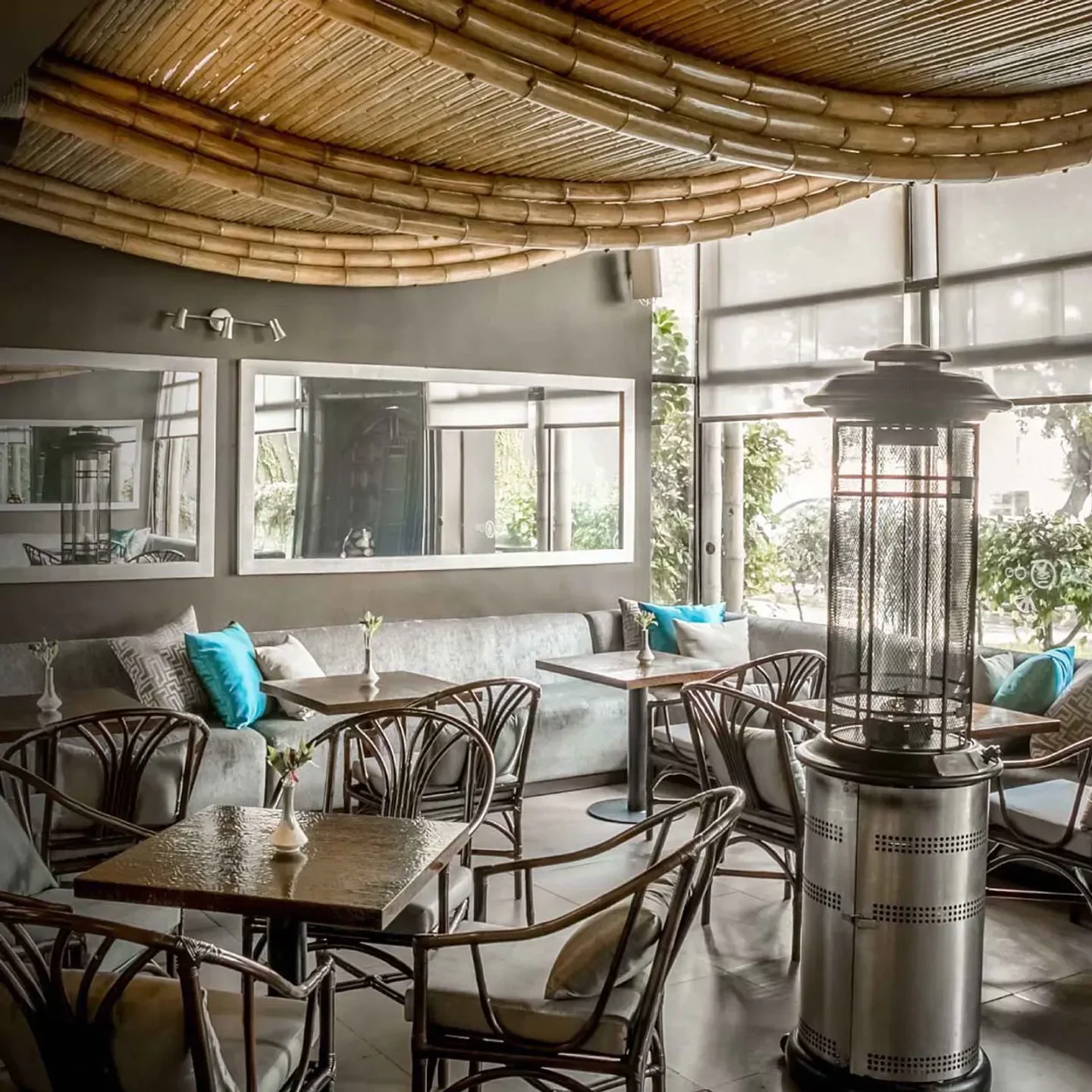 Interior of Costanera 700 restaurant in Lima, featuring bamboo ceiling and cozy seating.