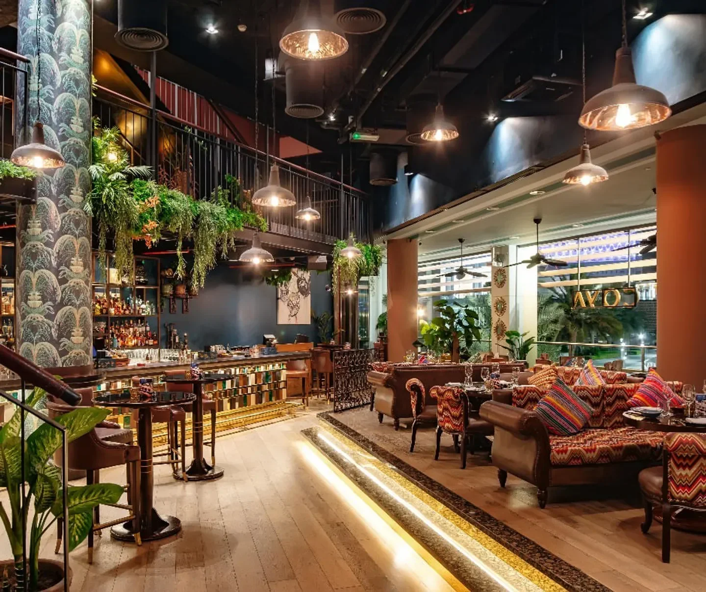 Interior of COYA Abu Dhabi restaurant, showing bar, seating, and decor.