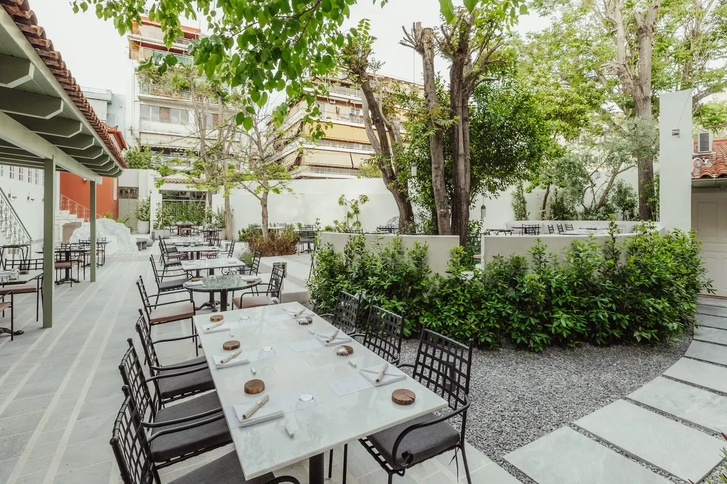 Outdoor dining at CTC Urban Gastronomy in Athens, a stylish restaurant with lush greenery.