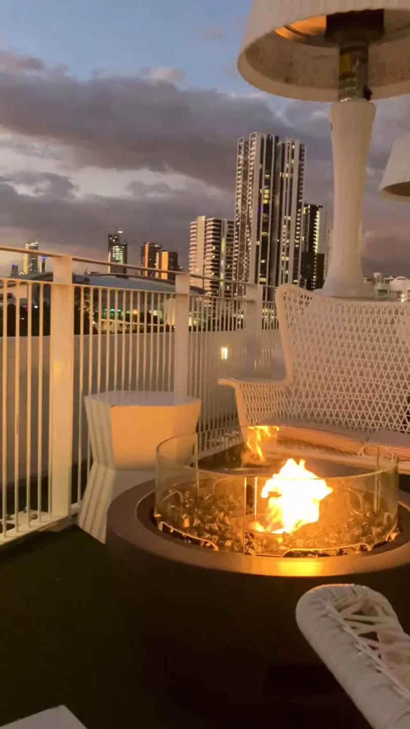Rooftop view from Cucina Vivo restaurant in Gold Coast with a cozy fire pit and city skyline at dusk