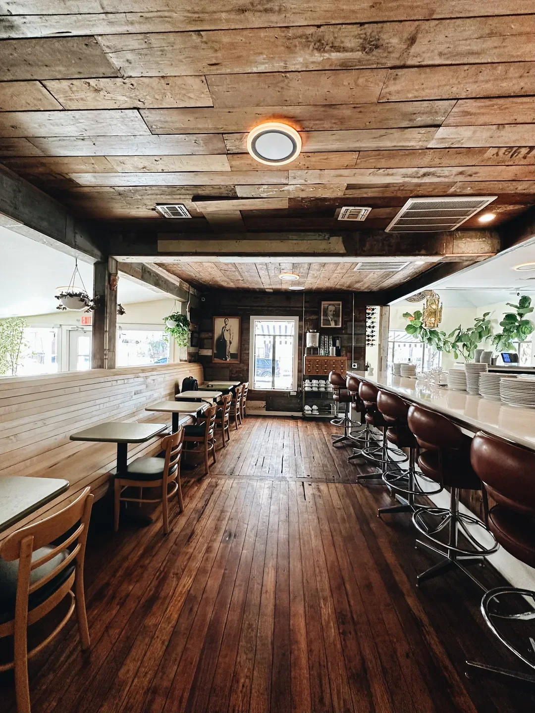 Interior of Cullum's Attaboy restaurant in San Antonio with wood decor and bar seating.