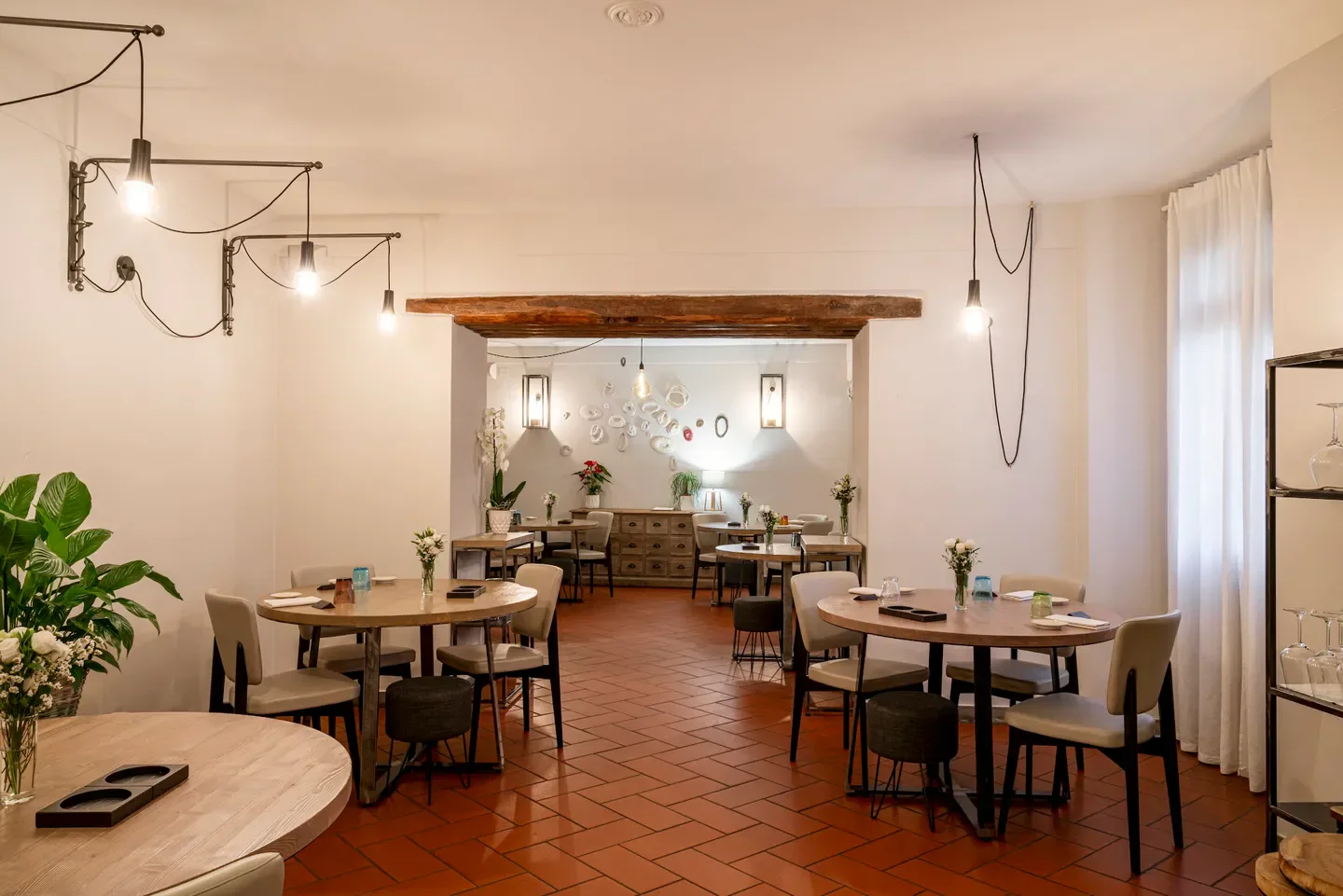 Interior of Da Gorini restaurant in Emilia-Romagna, featuring tables, chairs, and stylish decor.