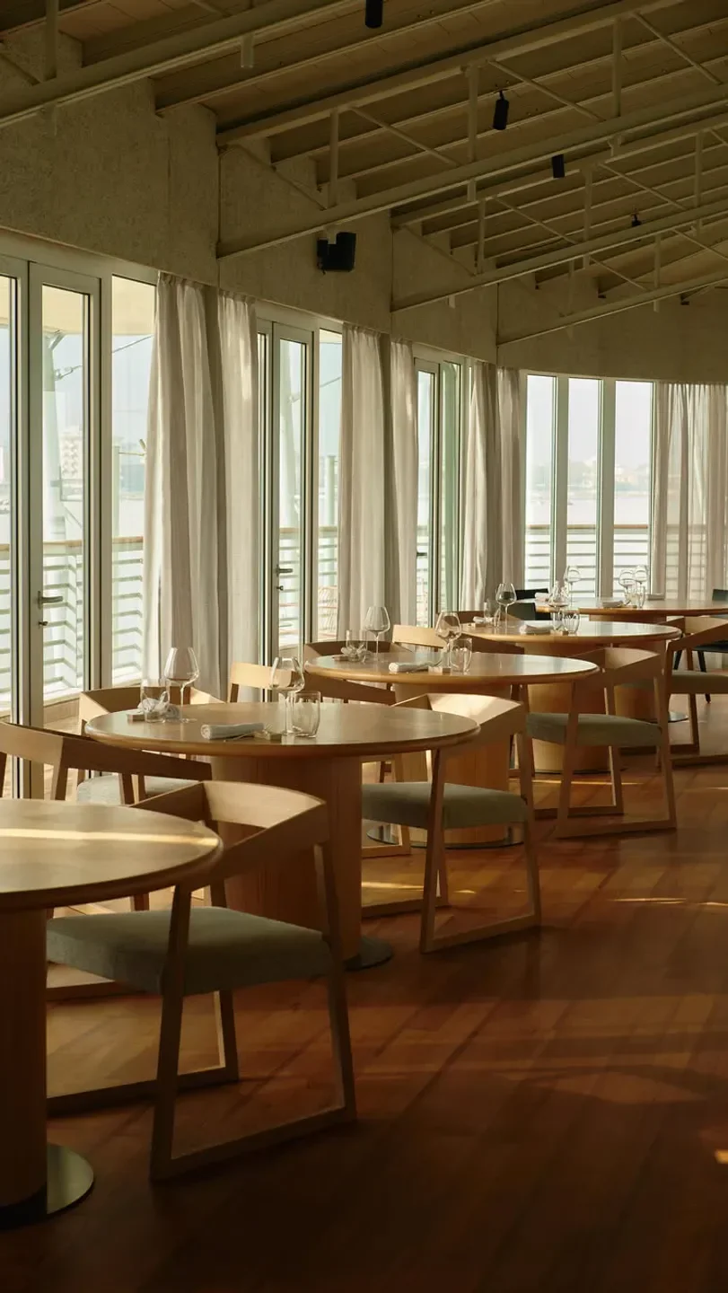 Interior of Da Lucio Trattoria in Emilia-Romagna, Italy, featuring elegant dining tables and chairs.
