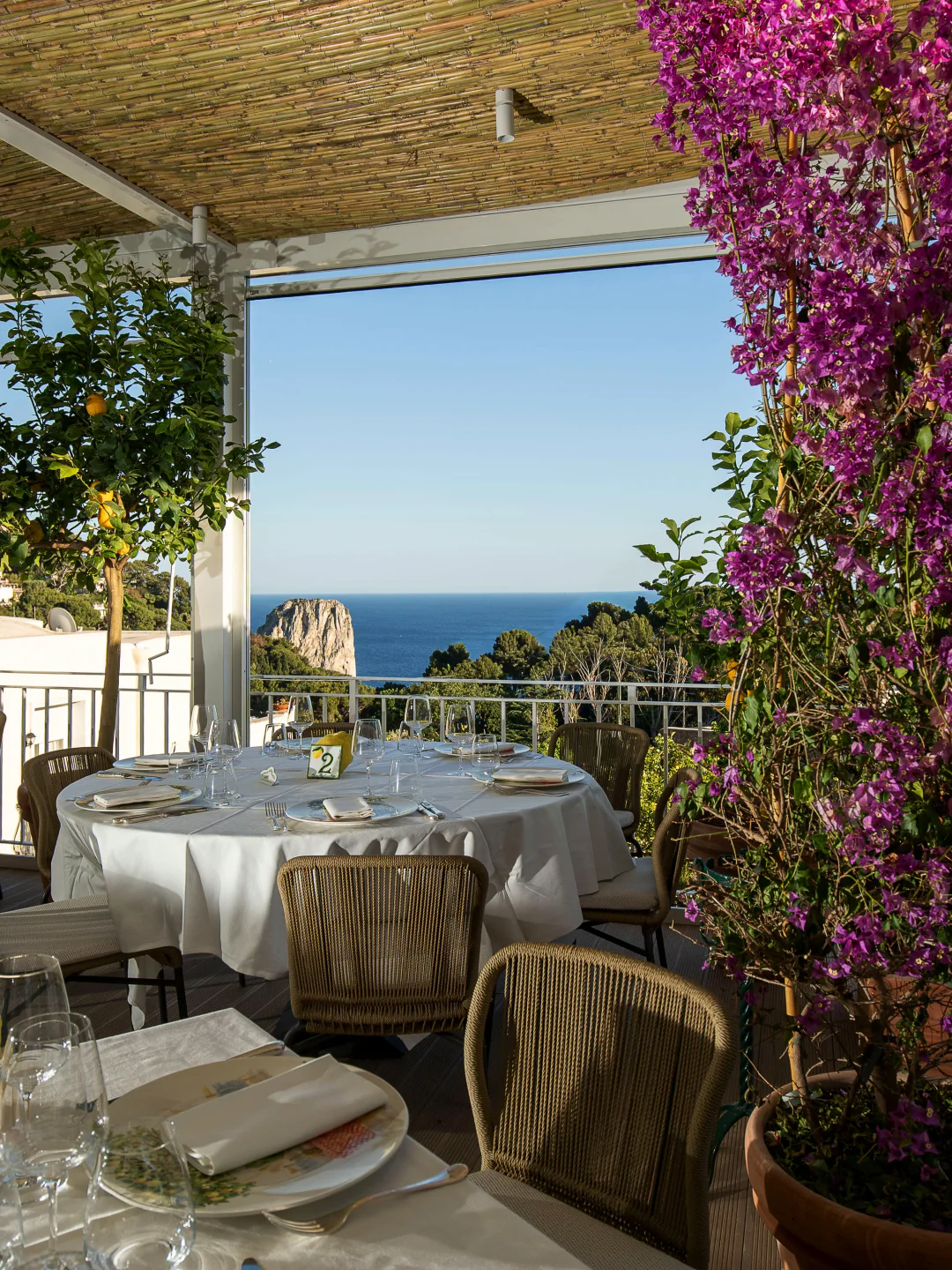 Table setting at Da Paolino restaurant in Capri with ocean view and blooming flowers