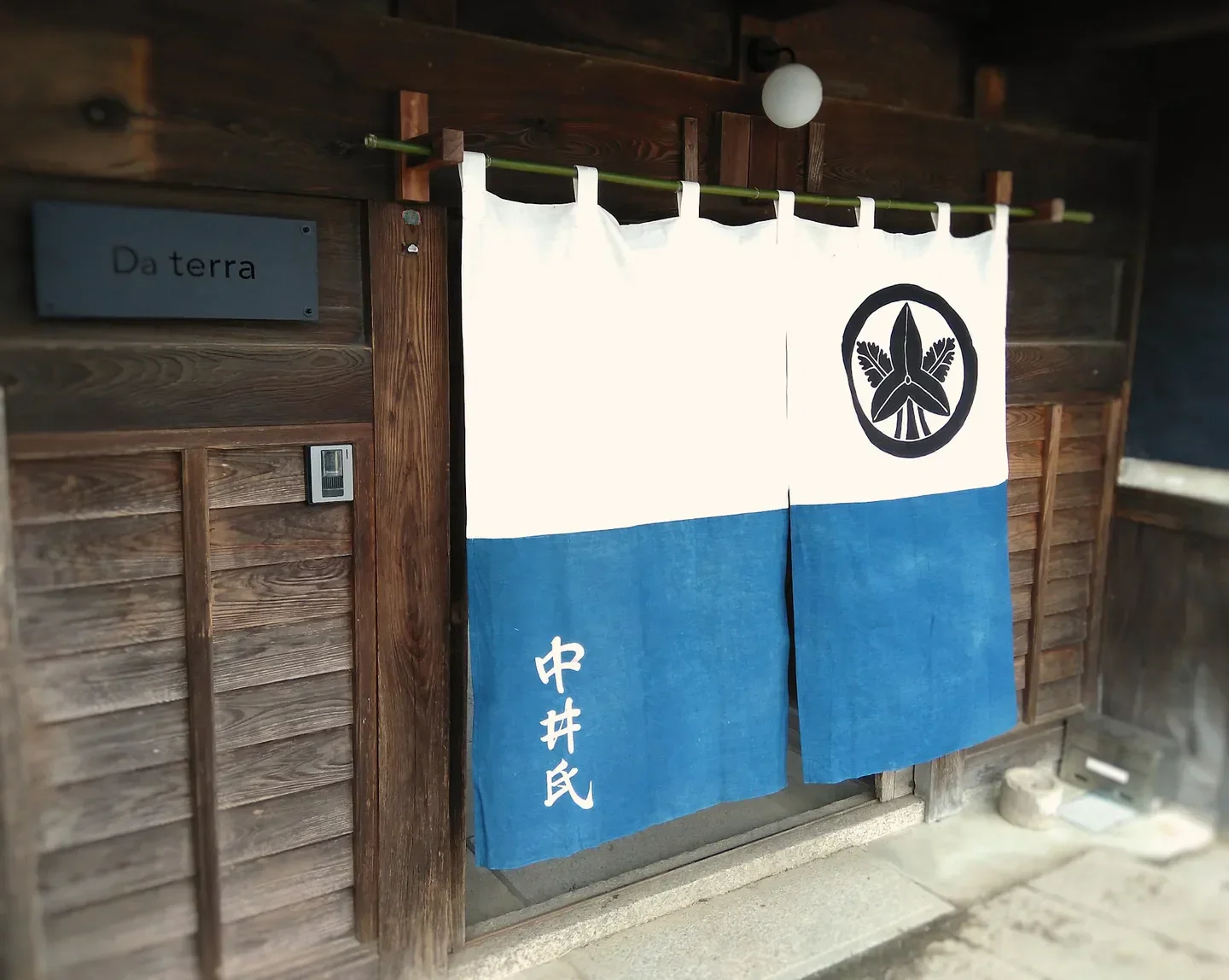 Entrance of Da terra restaurant in Nara, Japan, with traditional Japanese curtain.
